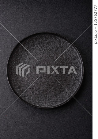 An empty round ceramic plate on a table, kitchenware. An empty plate 135762777