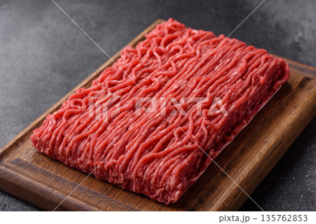 Raw ground beef or pork for burgers or meatballs with salt and spices. Raw ground beef 135762853