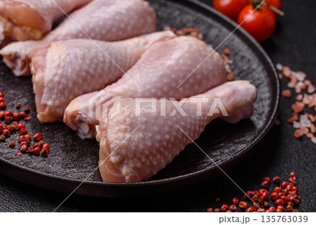 Chicken meat, raw drumsticks on the bone for grilling with salt and spices. Raw chicken drumsticks Chicken meat, raw drumsticks on the bone for grilling with salt and spices. Raw chicken drumsticks 135763039