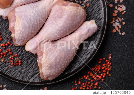 Chicken meat, raw drumsticks on the bone for grilling with salt and spices. Raw chicken drumsticks 135763040