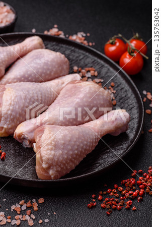 Chicken meat, raw drumsticks on the bone for grilling with salt and spices. Raw chicken drumsticks Chicken meat, raw drumsticks on the bone for grilling with salt and spices. Raw chicken drumsticks 135763042