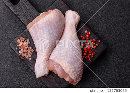 Chicken meat, raw drumsticks on the bone for grilling with salt and spices. Raw chicken drumsticks Chicken meat, raw drumsticks on the bone for grilling with salt and spices. Raw chicken drumsticks 135763056