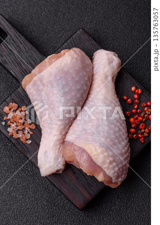 Chicken meat, raw drumsticks on the bone for grilling with salt and spices. Raw chicken drumsticks Chicken meat, raw drumsticks on the bone for grilling with salt and spices. Raw chicken drumsticks 135763057