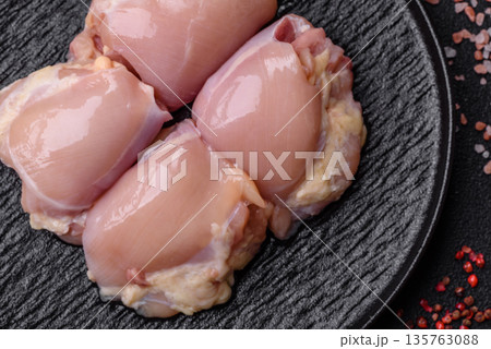 Chicken meat, raw boneless thigh fillets for grilling with salt. Raw chicken thigh fillets Chicken meat, raw boneless thigh fillets for grilling with salt. Raw chicken thigh fillets 135763088