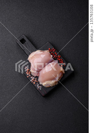 Chicken meat, raw boneless thigh fillets for grilling with salt. Raw chicken thigh fillets Chicken meat, raw boneless thigh fillets for grilling with salt. Raw chicken thigh fillets 135763108