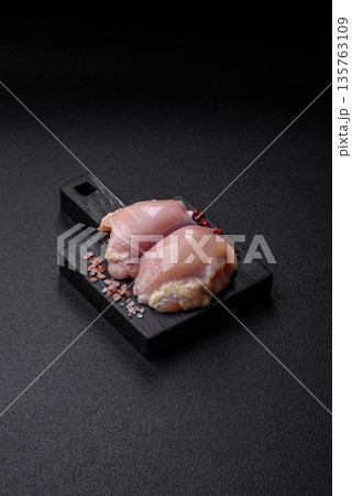 Chicken meat, raw boneless thigh fillets for grilling with salt. Raw chicken thigh fillets Chicken meat, raw boneless thigh fillets for grilling with salt. Raw chicken thigh fillets 135763109