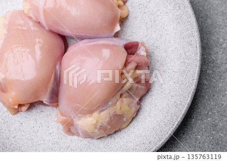Chicken meat, raw boneless thigh fillets for grilling with salt. Raw chicken thigh fillets Chicken meat, raw boneless thigh fillets for grilling with salt. Raw chicken thigh fillets 135763119