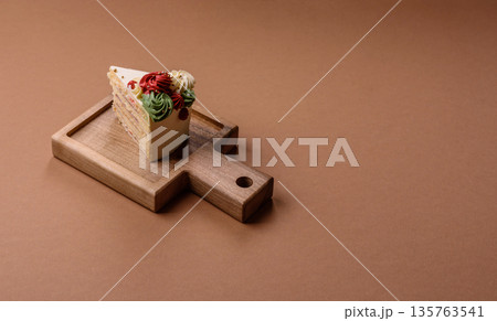 A slice of sweet layered cake with white cream for a birthday or holiday. A slice of cake 135763541