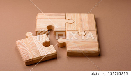 A wooden empty puzzle piece for a sign or business concept. A wooden empty puzzle 135763856