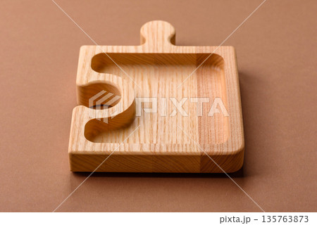 Wooden empty puzzle serving tray, kitchen accessories. A wooden empty puzzle tray 135763873