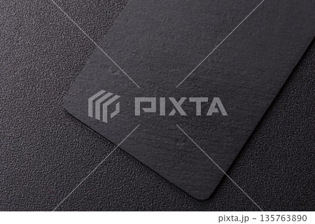 A black slate stone board or plate, an empty kitchen utensil. A black slate board A black slate stone board or plate, an empty kitchen utensil. A black slate board 135763890