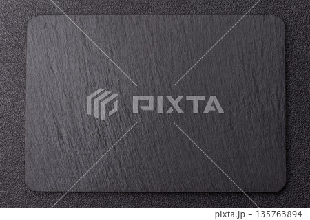 A black slate stone board or plate, an empty kitchen utensil. A black slate board 135763894