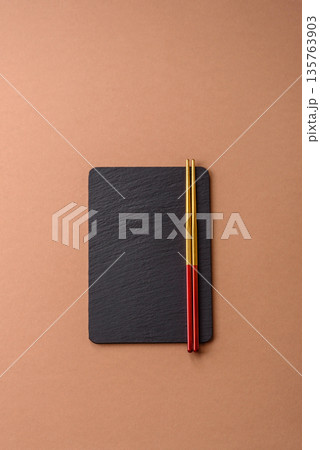 A black slate stone board or plate, an empty kitchen utensil. A black slate board A black slate stone board or plate, an empty kitchen utensil. A black slate board 135763903