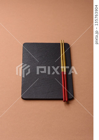 A black slate stone board or plate, an empty kitchen utensil. A black slate board A black slate stone board or plate, an empty kitchen utensil. A black slate board 135763904