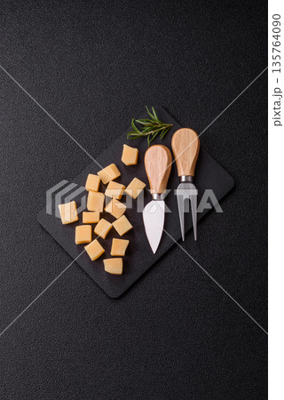 Cubed cheddar, gouda, or parmesan cheese on a cutting board. Cubed cheese Cubed cheddar, gouda, or parmesan cheese on a cutting board. Cubed cheese 135764090