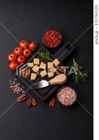 Cubed cheddar, gouda, or parmesan cheese on a cutting board. Cubed cheese 135764105