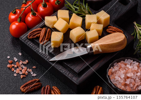 Cubed cheddar, gouda, or parmesan cheese on a cutting board. Cubed cheese Cubed cheddar, gouda, or parmesan cheese on a cutting board. Cubed cheese 135764107