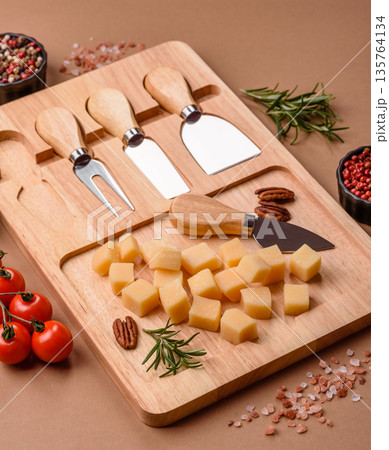 Cubed cheddar, gouda, or parmesan cheese on a cutting board. Cubed cheese 135764134