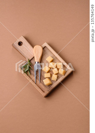 Cubed cheddar, gouda, or parmesan cheese on a cutting board. Cubed cheese 135764149