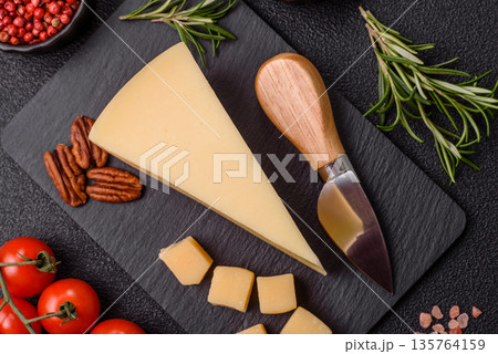 A wedge of cheddar, gouda, or parmesan cheese on a cutting board. Cheese wedge A wedge of cheddar, gouda, or parmesan cheese on a cutting board. Cheese wedge 135764159