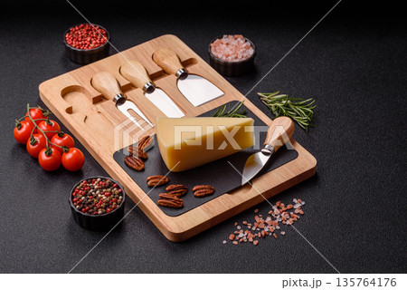 A wedge of cheddar, gouda, or parmesan cheese on a cutting board. Cheese wedge A wedge of cheddar, gouda, or parmesan cheese on a cutting board. Cheese wedge 135764176