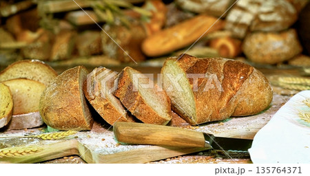 Rustic Bread Setup With Baking Tools, Cozy Kitchen Scene Featuring Assorted Freshly Baked Loaves 135764371