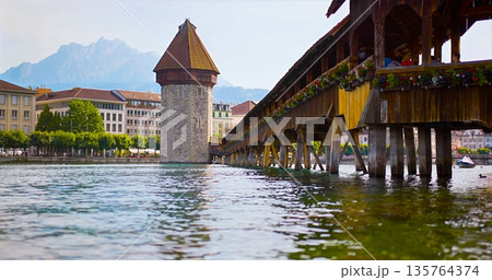 Old Wooden Bridge Over Water, Traditional Wooden Bridge Spanning Shimmering Mountain River 135764374