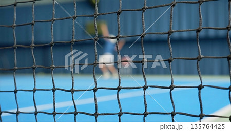 Action Shot Of Tennis Match, Player Executing Powerful Tennis Serve Over Vibrant Court Surface Action Shot Of Tennis Match, Player Executing Powerful Tennis Serve Over Vibrant Court Surface 135764425