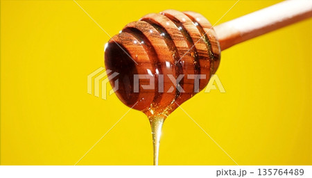 Honey Drizzle Closeup, Magnified Image Capturing Glossy Honey Pouring From Wooden Stick With Studio Lighting Honey Drizzle Closeup, Magnified Image Capturing Glossy Honey Pouring From Wooden Stick With Studio Lighting 135764489
