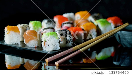 Collection Of Vividly Colored Sushi Artfully Positioned On Shiny Dark Base With Soft Lighting For Atmosphere Collection Of Vividly Colored Sushi Artfully Positioned On Shiny Dark Base With Soft Lighting For Atmosphere 135764490