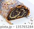 Mouth-watering pastry with rich poppy seed filling topped with crushed peanuts. Macro shot of dough and filling texture on white 135765284