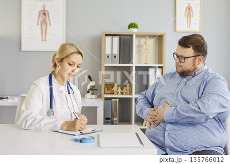 Doctor discuss treatment with fat overweight patient suffering from stomachache  135766012