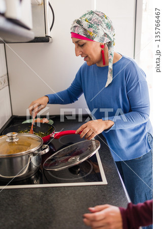 Mother with cancer cooking with daughter at home Mother with cancer cooking with daughter at home 135766467