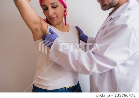 Doctor examining woman for breast cancer detection Doctor examining woman for breast cancer detection 135766473