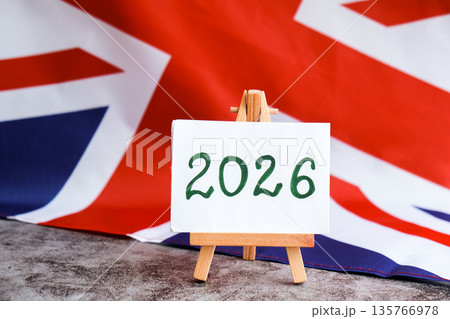 Paper note with text 2026 on National symbol of Great Britain. British wave the UK silky flag background. Financial outlook planning, new year annual report 135766978