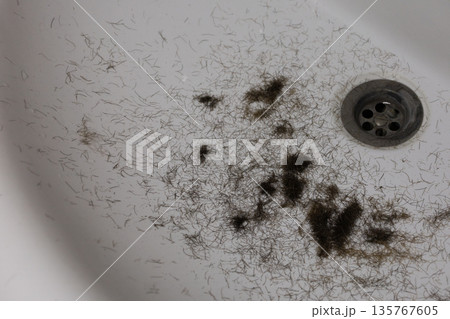 Man trimming beard and beard clippings in sink Man trimming beard and beard clippings in sink 135767605