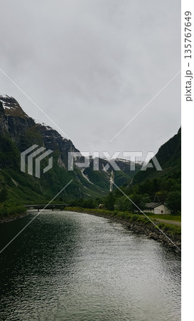 A boat water in front of mountain. Water calm and clear.  135767649