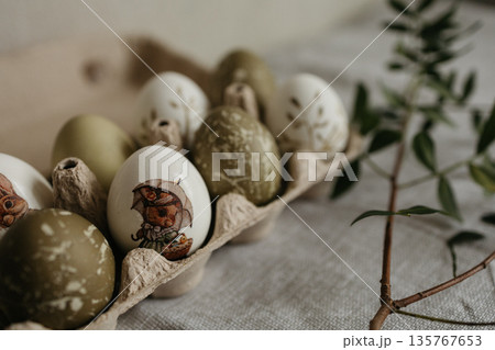 Easter holiday. Painted olive-colored eggs on a linen tablecloth. Easter decoration. 135767653