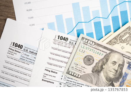 Tax form 1040 U.S. Individual Income Tax Return with dollar banknotes money. 135767853