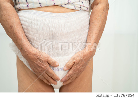 Asian senior woman patient wearing adult incontinence diaper pad in hospital. 135767854