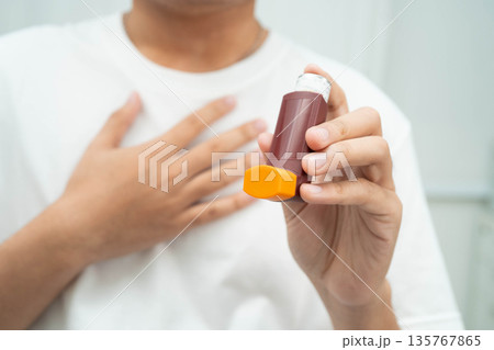 Asthma and chronic obstructive pulmonary disease COPD, Asian teenage using metered dose inhaler MDI. Asthma and chronic obstructive pulmonary disease COPD, Asian teenage using metered dose inhaler MDI. 135767865