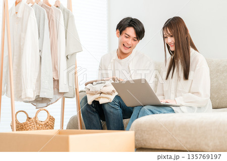 フリマサイトに洋服を出品する若いアジア人カップル(フリーマーケット,リユース,出品) フリマサイトに洋服を出品する若いアジア人カップル(フリーマーケット,リユース,出品) 135769197