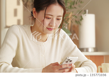 リラックスしながらスマホを見る女性 リラックスしながらスマホを見る女性 135771036
