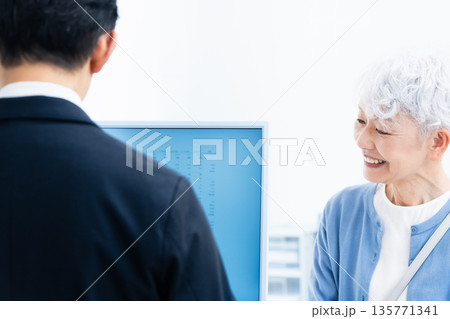 窓口で手続きをするシニア女性 135771341
