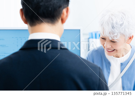 窓口で手続きをするシニア女性 135771345