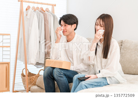 家のリビングでソファーでテレビを見る若いアジア人夫婦,カップル（感動,涙,涙活） 135772509