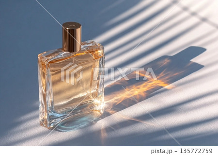 A chic cosmetic glass bottle lies on thin parallel shade lines in the rays of the sun. A copy space. A blank bottle mockup. product advertising 135772759