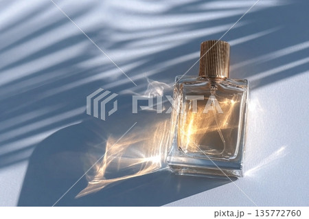 A chic cosmetic glass bottle lies on thin parallel shade lines in the rays of the sun. A copy space. A blank bottle mockup. product advertising A chic cosmetic glass bottle lies on thin parallel shade lines in the rays of the sun. A copy space. A blank bottle mockup. product advertising 135772760