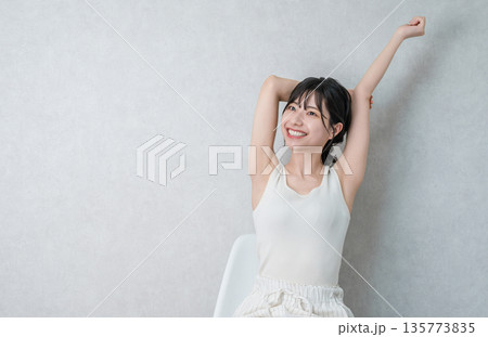 家で椅子に座ってストレッチ・深呼吸するアジア人女性 家で椅子に座ってストレッチ・深呼吸するアジア人女性 135773835
