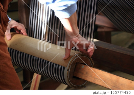 秩父銘仙館の整経機で巻き取られる経糸 135774450